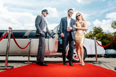 couple arriving with limousine walking red carpet