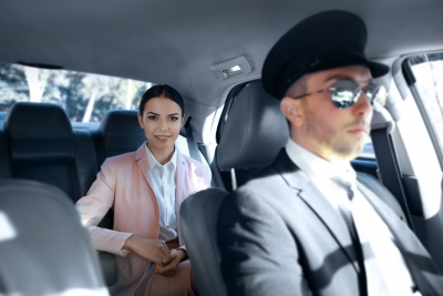 businesswoman riding a car with chauffeur